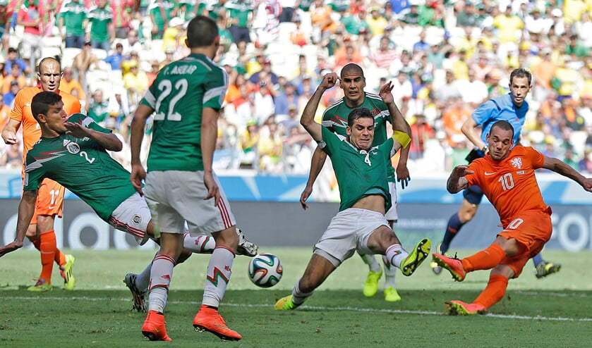 Wesley Sneijder haalt uit in de achtste finale op het WK voetbal in 2014 tegen Mexico. Oranje stond in die wedstrijd lang op achterstand. In de 88e minuut maakte Sneijder de gelijkmaker, waarna Nederland uiteindelijk met 2-1 won. (ap / Natacha Pisarenko)