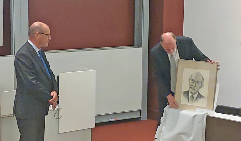 Een zoon van Cornelis Graafland (links) overhandigt aan Henk van den Belt een portret van zijn vader, dat jaren bij zijn ouders op zolder lag. (nd)