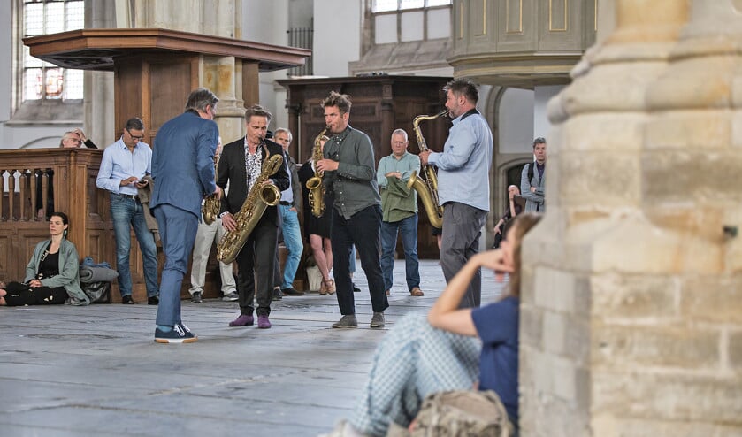 Concertgangers in de Oude Kerk mogen zelf hun luisterplek kiezen, in de banken of op de grond. (oude kerk / Maarten Nauw)