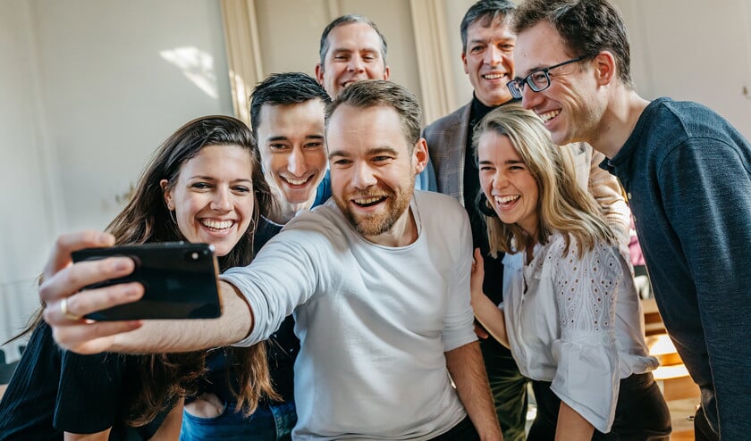 Henrik Wienen (met telefoon) gelooft dat kerk-apps een middel kunnen zijn om een plaatselijke kerkgemeenschap hechter te maken. (Leonard Walpot)