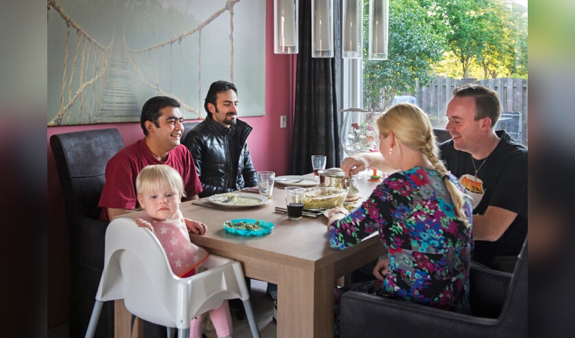 Het gezin Bos uit Apeldoorn nodigt twee Syrische vluchtelingen uit om bij hen thuis te komen eten. ‘Veel mensen zijn bereid vluchtelingen te helpen, maar vaak weten ze niet precies wat ze kunnen doen’, aldus Mariëlle Beusmans. (anp / Piroschka van de Wouw)