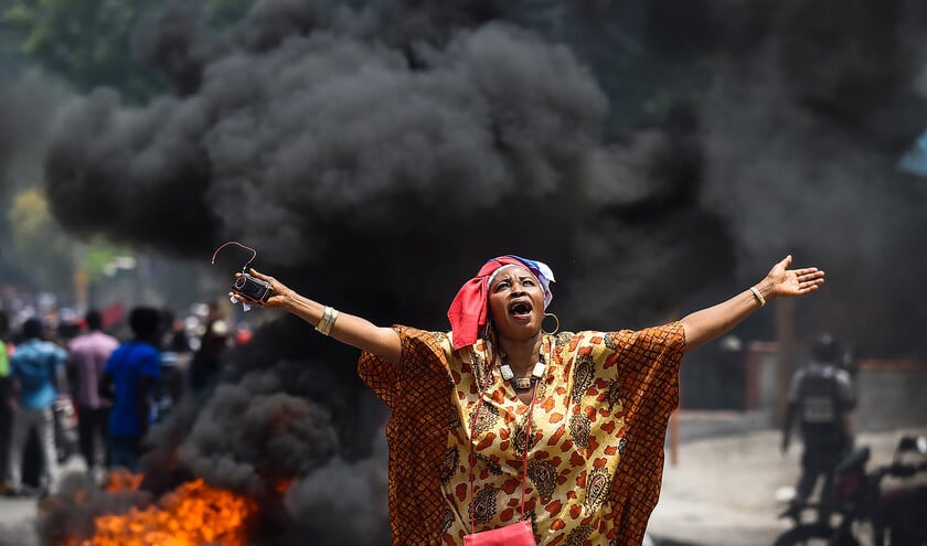 Een deelneemster roept leuzen tegen de regering, tijdens een betoging in de Haïtiaanse hoofdstad Port-au-Prince. Volgens de betogers is de regering corrupt. (afp / Chandan Khanna)