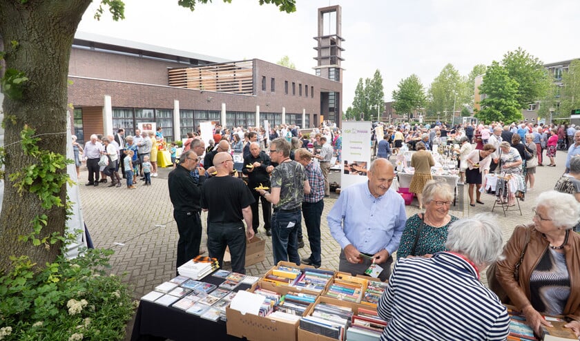 De bezoekers van de Kerkendag laten de kraampjes op de parkeerplaats naast het kerkgebouw niet links liggen. (Niek Stam)