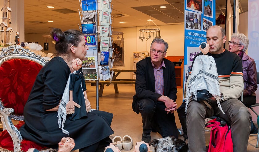 Kunstenares Jacquelien Gosschalk vertelt een verhaal met poppen in de kerkelijke pop-upwinkel Mooi Verhaal. Initiator Bert Altena (midden): ‘Dit smaakt naar meer.’ (Philip Roorda)