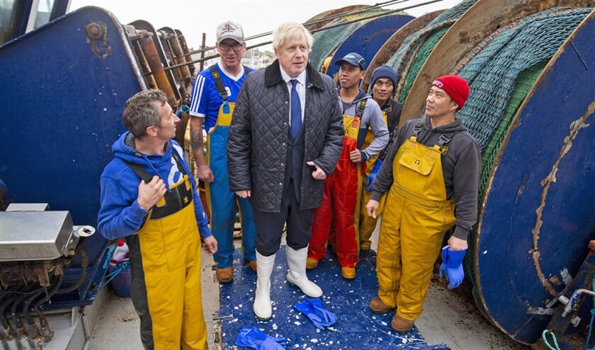 Premier Boris Johnson (midden) ontmoet de crew van trawler Opportunis IV tijdens een bezoek aan Peterhead in Schotland. Een trawler is een vissersschip dat met een trechtervormig net vist. (afp / Duncan McGlynn)