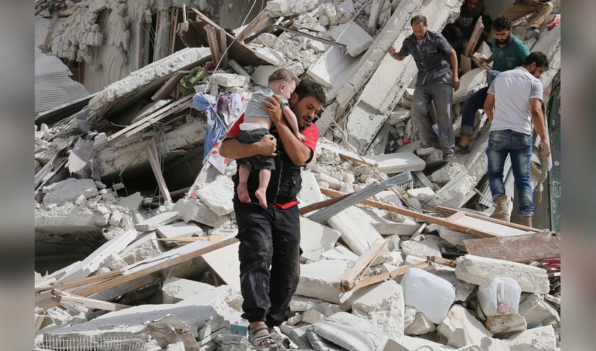 Een man draagt een kind weg uit de puinhopen die het gevolg zijn van luchtaanvallen op de door rebellen gecontroleerde wijk al-Qaterji van Aleppo. (reuters / Abdalrhman Ismail)