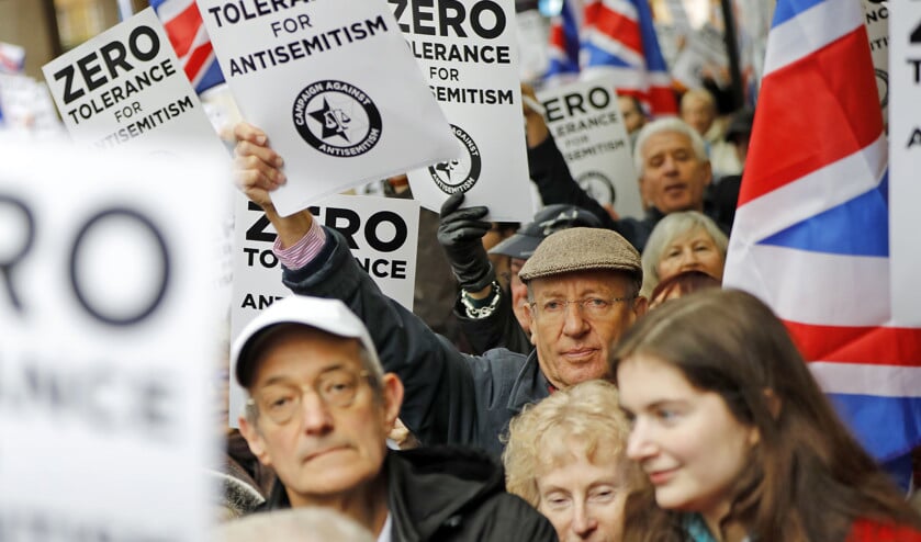 Buiten het hoofdkantoor van de Britse Labourpartij in Londen betogen mensen met pamfletten en vlaggen tegen het antisemitisme binnen de oppositiepartij van Jeremy Corbyn. (afp / Tolga Akmen)