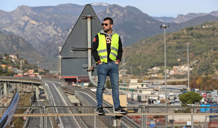 Een demonstrant met een geel vest staat op een brug tijdens een demonstratie op 22 december 2018 in Ventimiglia, bij de Frans-Italiaanse grens. De demonstratie was gericht tegen het beleid van president Emmanuel Macron. (afp / Valéry Hache)