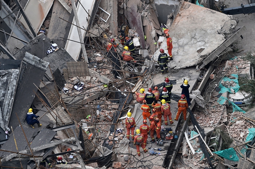 Reddingswerkers aan het werk in de Chinese stad Shanghai, waar donderdag negen bouwvakkers bedolven raakten toen het dak van een bedrijf dat auto’s verkoopt instortte. De bouwvakkers waren juist bezig het pand te renoveren. Veertien mensen konden levend onder het puin vandaan gehaald worden. < (afp / Hector Retamal)