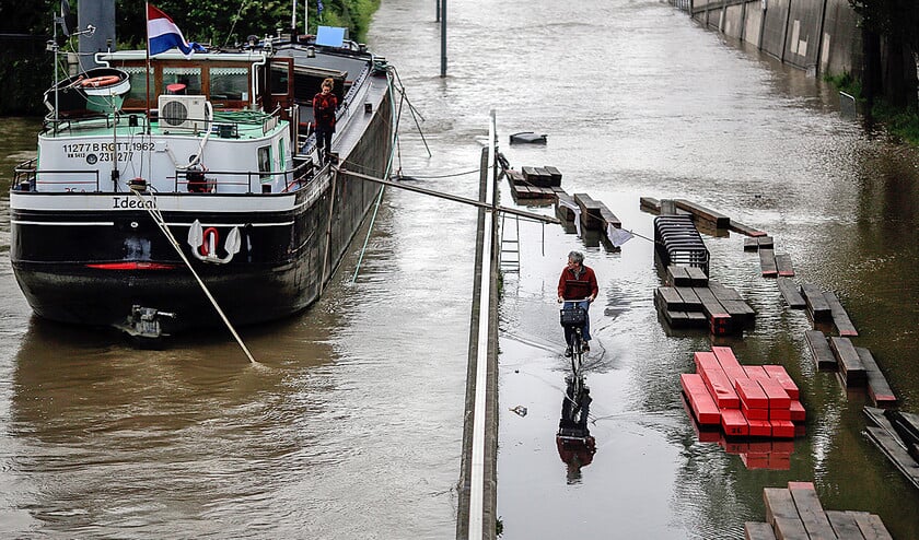 Een fietser rijdt over een ondergelopen weg langs de Seine in Parijs. In de Franse hoofdstad is de afgelopen maand driemaal zoveel neerslag gevallen als in een normale meimaand. (ap / Markus Schreiber, Matthias Schrader en anp)