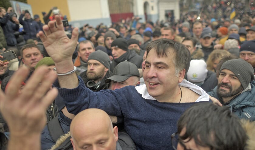 Oppositieleider Michaïl Saakasjvili wordt omringd door zijn aanhangers die hem eerder uit een politiebusje hebben bevrijd. (ap / Evgeniy Maloletka)