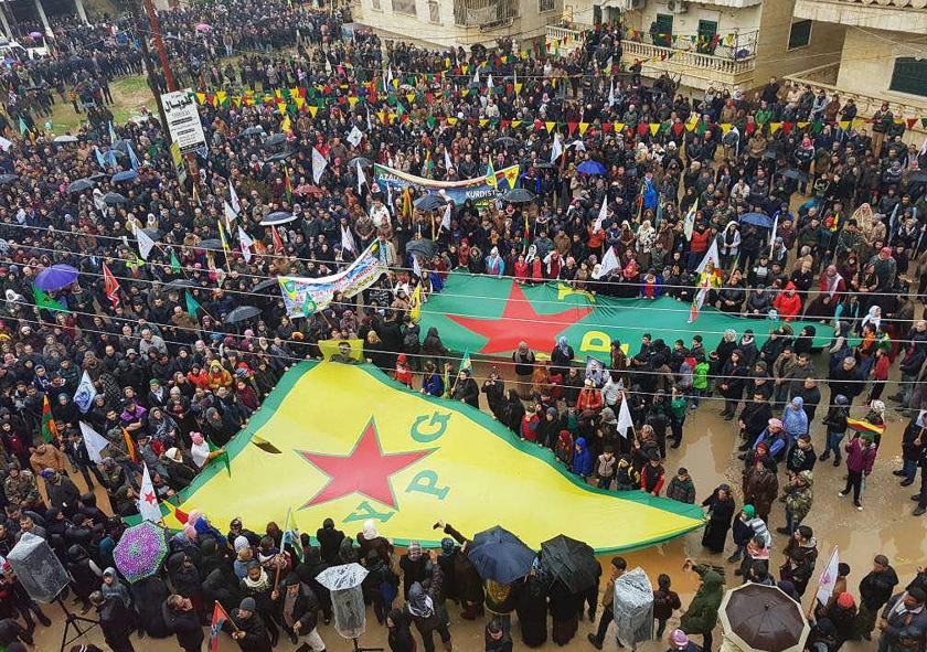 Koerden die in Afrin betogen tegen Turkse bedreigingen zwaaien met vlaggen van de YPG en andere partijen. (ap)