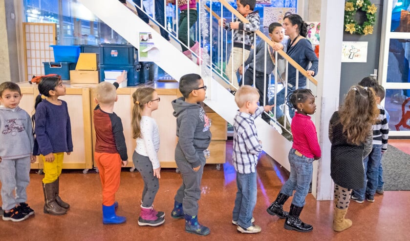 Kinderen uit de onderbouw zijn op weg naar de grote gymzaal boven, waar ze gaan oefenen voor een voorstelling voor de ouders. (David van Dam)