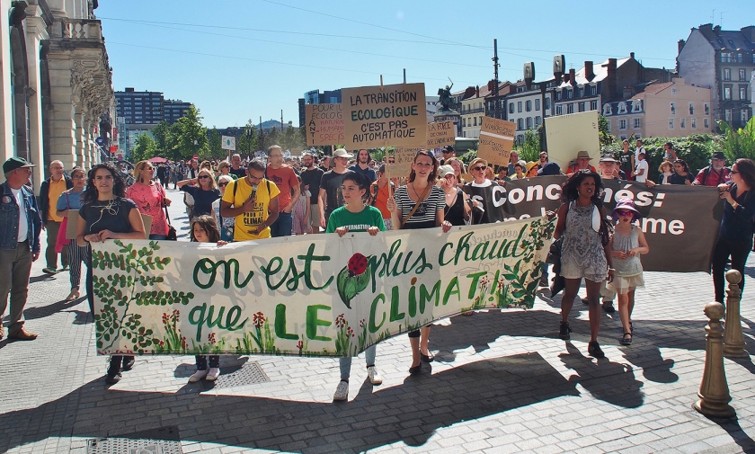 ‘Wij zijn heter dan het klimaat’ staat op een spandoek dat bij de mars in Clermont-Ferrand werd meegedragen. (Imco Lanting)