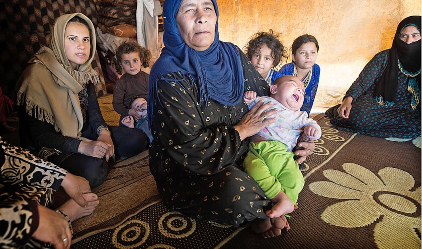 Tijdens een voorlichtingsbijeenkomst over gezinsplanning, ontfermt Rania (m.) zich over het jongste kind van Nour, een 26-jarige moeder van vijf kinderen. (nd)