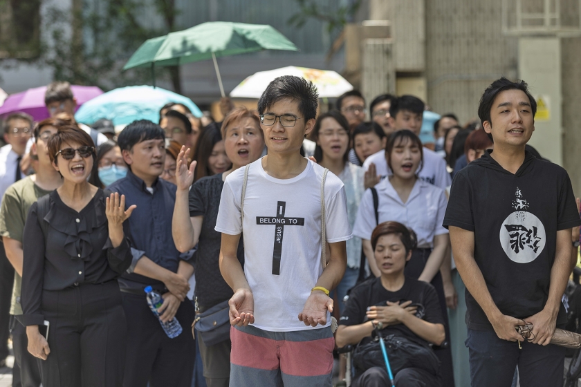 Jonge christenen laten via het zingen van lofzangen weten dat ze het pertinent oneens zijn met de wet die het uitleveren van verdachten aan de autoriteiten op het Chinese vasteland makkelijker maakt. (epa / Jerome Favre)