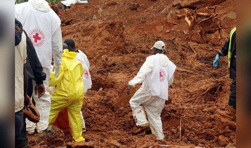 Reddingswerkers in Sierra Leone zoeken onder de modder in de krottenwijken naar slachtoffers. (epa / Ernest Henry en efsl)