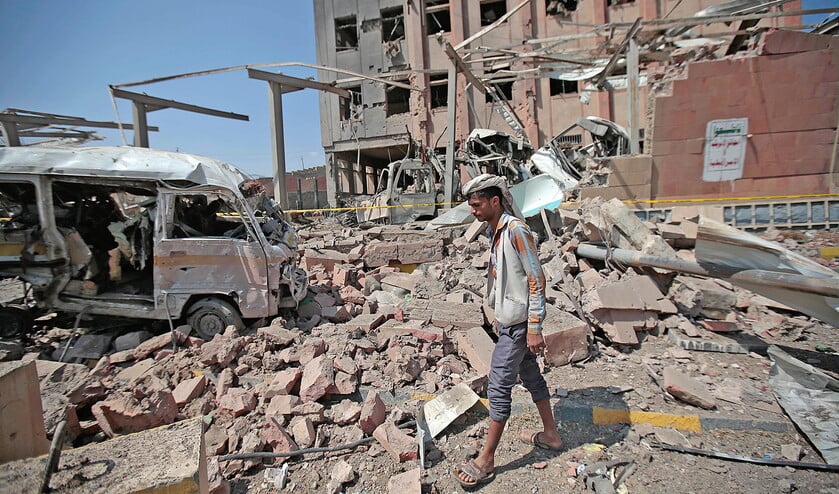 Een man bekijkt de schade die luchtaanvallen van de door Saudi-Arabië geleide coalitie begin februari in de Jemenitische stad Sanaa maakten. Doel van de coalitie is vooral om politieke vrienden daar in het zadel te houden. (ap / Hani Mohammed)