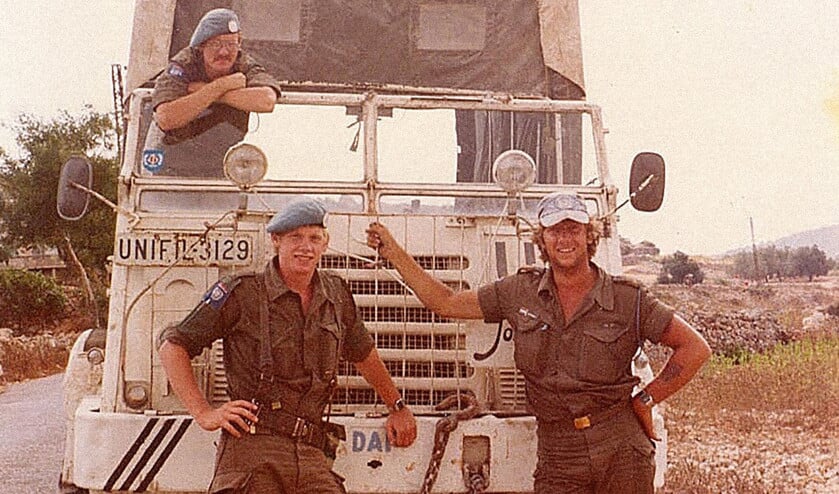 Bert Kleine Schaars leunend op de voorruit van een 3-tonner tijdens de missie, samen met twee maten. Degene rechts is Joop Alsemgeest, de chauffeur. (privébezit Bert Kleine Schaars)