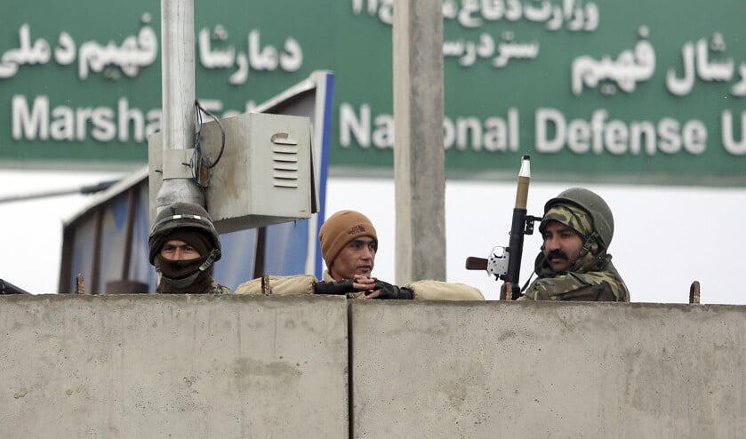 Afghaanse militairen op wacht bij de toegangspoort van de militaire academie in Kabul, na de aanslag op een legereenheid maandag. (ap / Rahmat Gul)