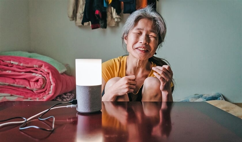 De bijna volledig blinde Jang Ae-ja (55) met de slimme speaker in haar huis in Seoul. (Jun Michael Park)