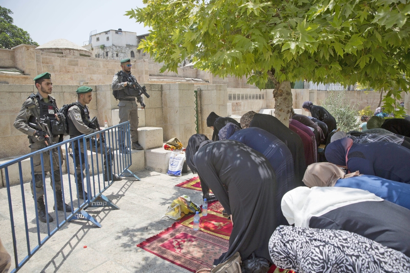 Palestijnen bidden dinsdag bij de Leeuwenpoort in Jeruzalem. Ze reageren op een oproep van geestelijken om niet in de moskee, maar hier te bidden. (ap / Oded Balilty)