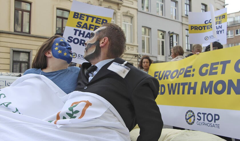 Vertegenwoordigers van het burgerinitiatief tegen onkruidverdelger glyfosaat demonstreerden vorige maand voor het EU-gebouw in Brussel. Een van hun slogans: ‘Europe: get out of bed with Monsanto’. (ap / Oliver Beckhoff)