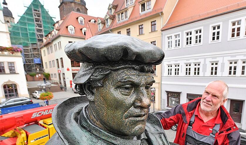 ‘Metaalconservator’ Ulrich Weidauer werpt een tevreden blik op een schone Luther in brons. Na een ‘korte’ schoonmaak- en opknapbeurt van zes weken keerde het beeld van Maarten Luther (1483-1546) deze week terug op het Marktplein in zijn geboortestad Eisleben. (nd, ap)