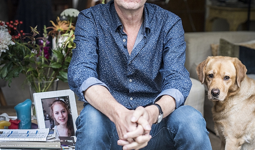 Koos Neuvel met een foto van zijn dochter Nora en met labrador Luna, die het gezin ooit in huis haalde voor Nora. (Linelle Deunk)