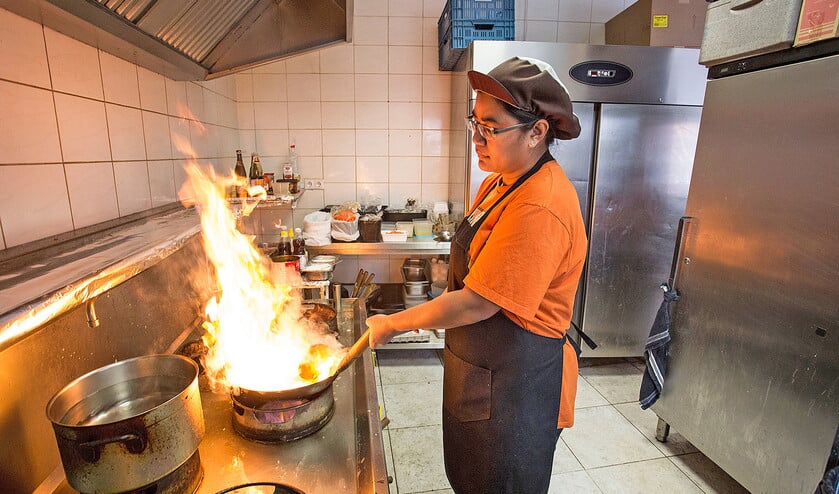 In het Thaise afhaalrestaurant Mathulada in Oud-Beijerland laait het vuur flink op. Bij het wokken wordt het gerecht kort flink verhit, dat kost even wat gas. (Arie Kievit)