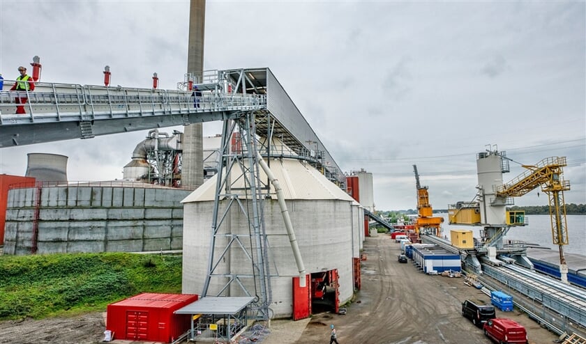 De aanvoerbanden en silo (links en midden) voor de opslag van biomassa bij de Amercentrale, rechts de schepen die de biomassa aanvoeren. (Raymond Rutting)