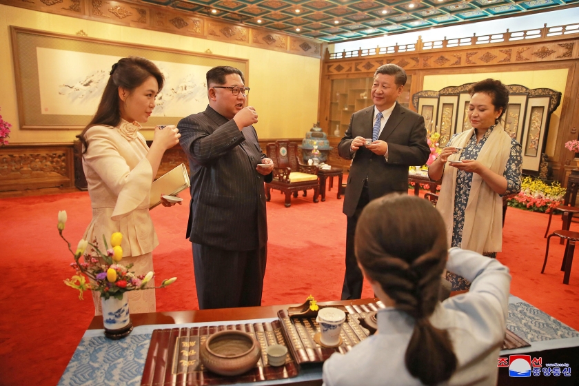 De Noord-Koreaanse leider Kim Jong-un en zijn vrouw (links) drinken thee met president Xi Jinping van China en diens echtgenote, woensdag in Peking.