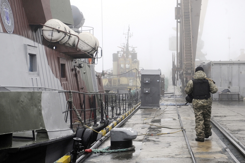 Een Oekraïense militair patrouilleert op de kade van de haven van Marioepol. De havenarbeiders zelf vervelen zich stierlijk nu de schepen de Zee van Azov niet uit kunnen. (afp / Aleksey Filippov)