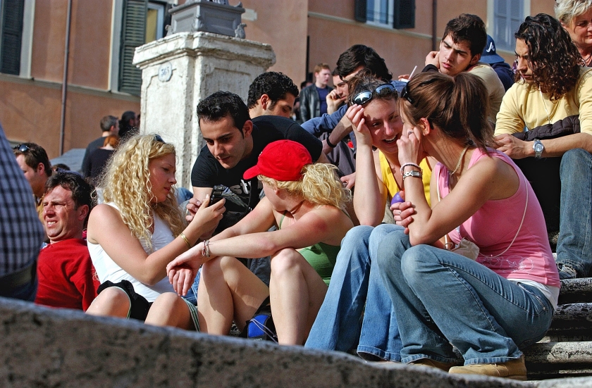 De beroemde Spaanse Trappen in Rome is een populaire plek bij toeristen om even op adem te komen. Vanaf de eeuwenoude treden wordt het thuisfront al whatsappend bijgepraat over hun belevenissen in de stad. (ap /Corrado Giambalvo)