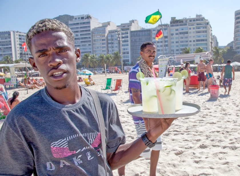 Een strandverkoper op Copacabana, met de populaire cocktail caipirinha. Achter het zonnige imago van Rio de Janeiro gaan veel problemen schuil. (ap / Herbert Knosowski)