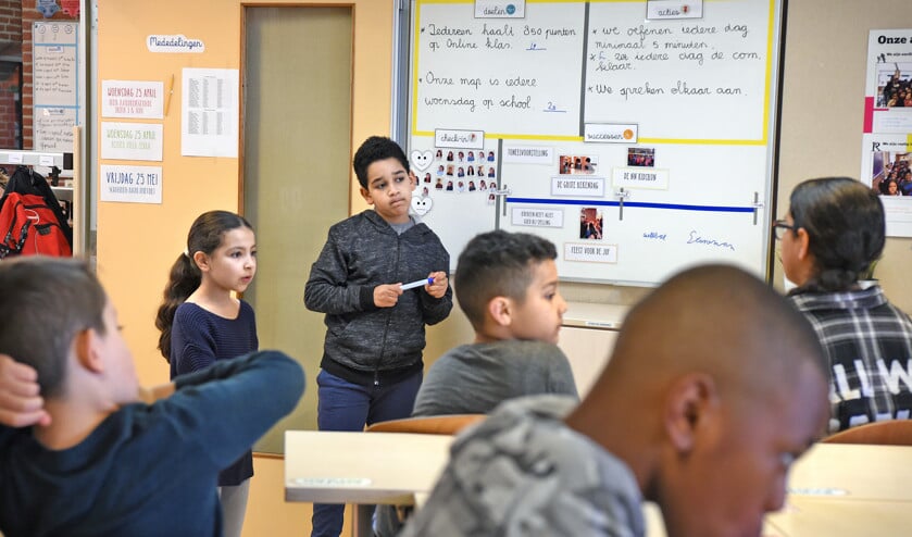 Op de Oscar Romeroschool in het Rotterdamse Crooswijk hebben twee leerlingen de regie aan het bord. (Marcel van den Bergh)