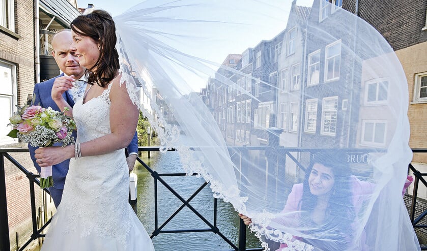 Een stelletje dat gaat trouwen laat de bruidsfoto’s maken op een van de vele bruggen in het oude deel van Dordrecht. (Guus Dubbelman)