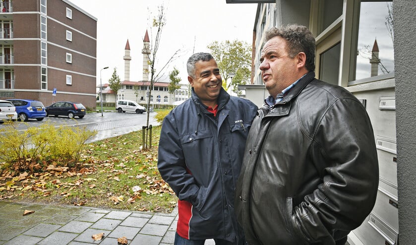 Mustapha El Achiri, wijkbeheerder van Rochdale, praat met Fadil, oorspronkelijk uit Kosovo, die al tientallen jaren in de wijk woont. (Guus Dubbelman)