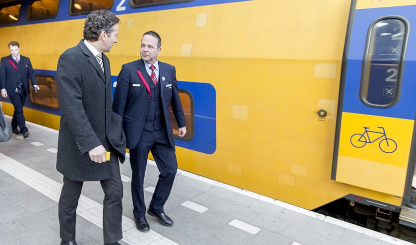 Minister van Financiën Jeroen Dijsselbloem voert tijdens een werkbezoek aan NS een gesprek met een conducteur van het spoorwegbedrijf. (anp / Jerry Lampen)