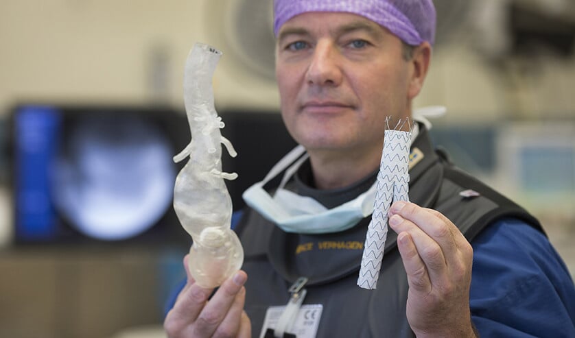 Vaatchirurg prof. Hence Verhagen toont een nieuw type stent voor behandeling van patiënten met een aneurysma. Op basis van beelden van een CT-scan is een mal gemaakt van de verwijde grote lichaamsslagader (aorta) van een patiënt. Verhagen houdt de mal vast ter hoogte van de positie van de aorta in de buik (foto rechts). (erasmus mc / Levien Willemse en anp)