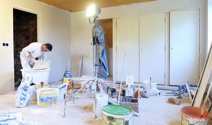 Een stukadoor aan het werk in een woning die gerenoveerd wordt. Dat is zwaar werk, maar stukadoors moeten nu nog net zo lang doorwerken voor ze aan hun AOW toe zijn als mensen die lichtere werkzaamheden verrichten. (anp / Lex van Lieshout)