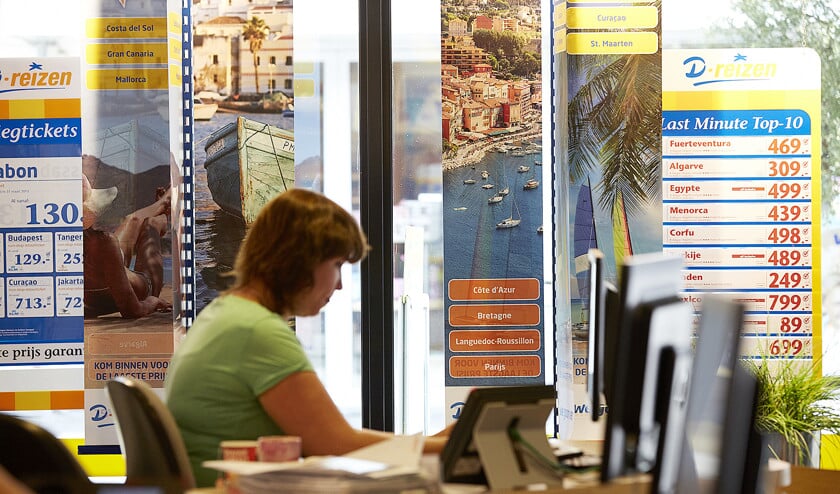 Een medewerker van reisbureau D-Reizen aan het werk. Nederlandse vakantiegangers zoeken massaal hun toevlucht in zonnige vakantieoorden. Binnenkort willen reisaanbieders meer duidelijkheid bieden over klimaateffecten. (anp / Martijn Beekman)