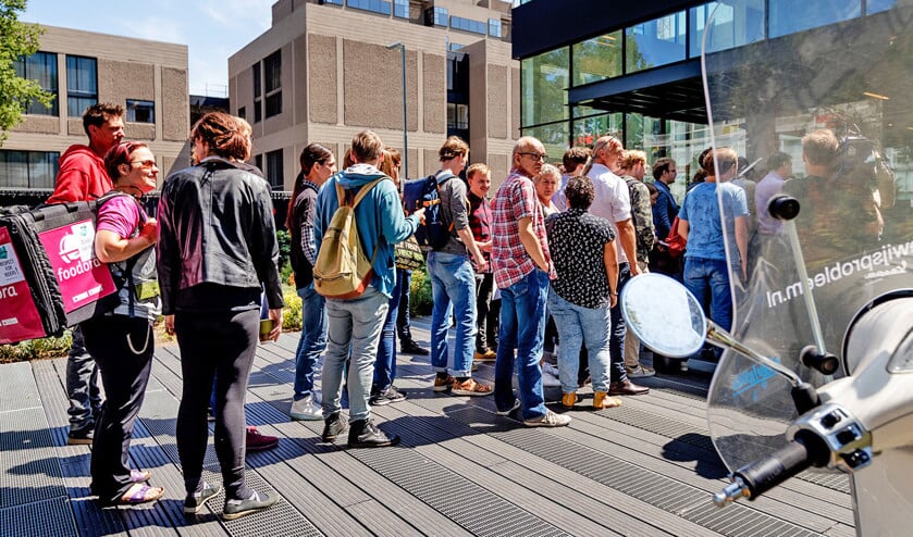 Medewerkers van Deliveroo verzamelden zich woensdag voor de rechtbank in Amsterdam. Daar boog de rechter zich over de vraag of de maaltijdbezorger een werkgever of een opdrachtgever is. (anp / Robin van Lonkhuijsen)