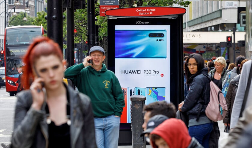 Een Huawei-advertentie bij een bushalte in het centrum van Londen. Binnenkort beslist het kabinet of Huawei mag meedoen met de aanleg van het nieuwe 5G-netwerk in Nederland. (afp / Tolga Akmen)