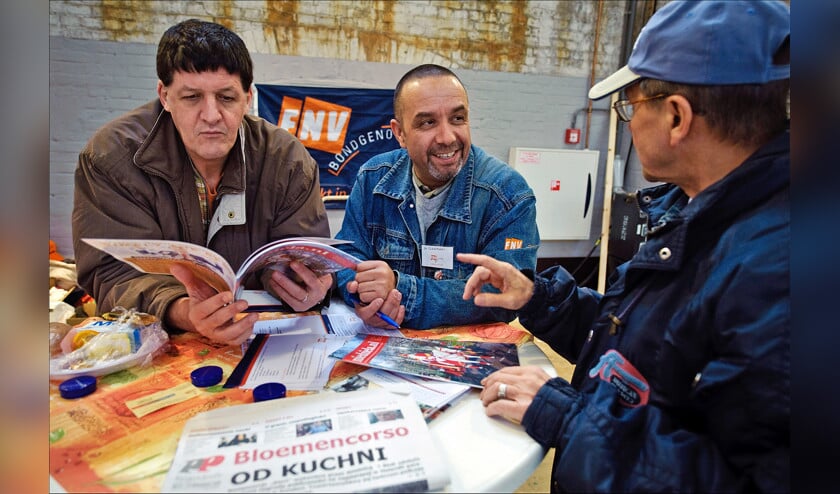 Een medewerker van de FNV (m) in gesprek met Poolse arbeiders op de Poolse Banenbeurs in de Westergasfabriek in Amsterdam. (anp / Erik van ’t Woud)