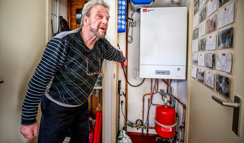 Mar Aalders bij de elektrische verwarmingsketel in zijn appartement in Middelburg. Na drie jaar gebruik heeft hij nog geen nadelen ontdekt. (Raymond Rutting)