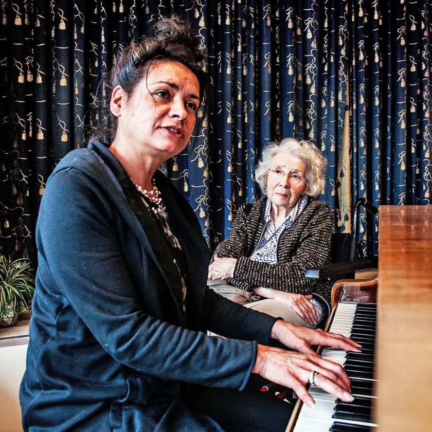 Begeleidster Brenda Frans speelt piano voor een cliënte. (Ton Koene en Aurélie Geurts)