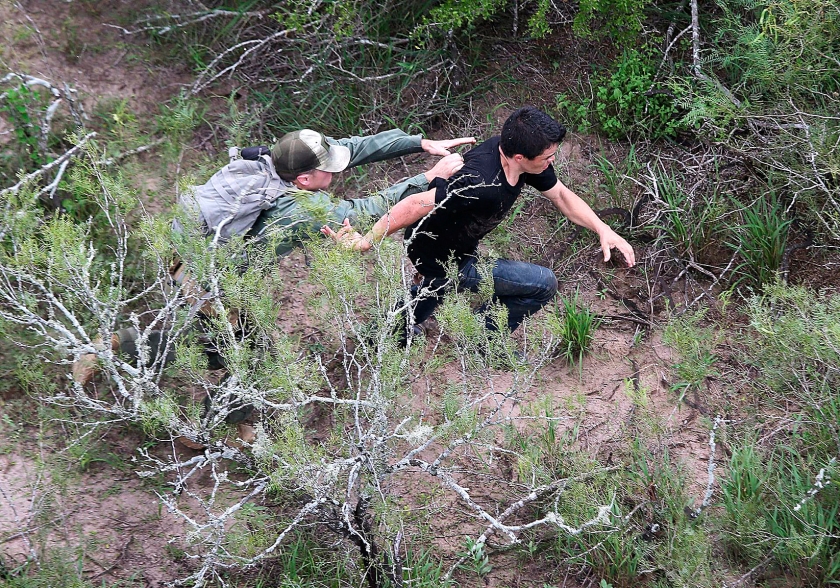 Een Amerikaanse agent probeert tevergeefs een Mexicaanse migrant te grijpen bij Falfurrias. De man werd later alsnog aangehouden.