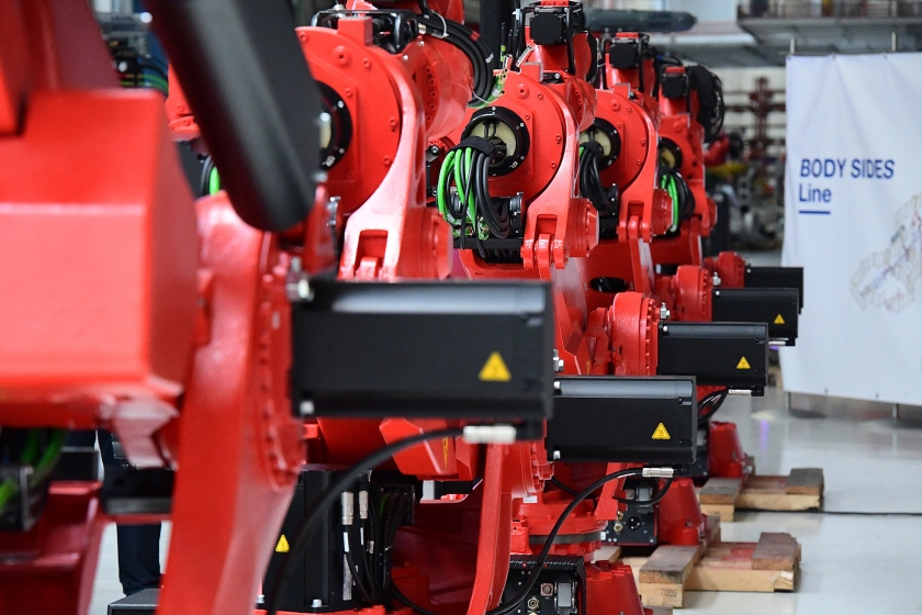 Een rij robots in de assemblagelijn van de elektrische Fiat 500 in de Fiat-fabriek in het Italiaanse Turijn. Door de opkomst van elektrische auto’s raken traditionele auto-onderdelen uit de gratie, en dat gaat banen kosten. (afp / Miguel Medina)