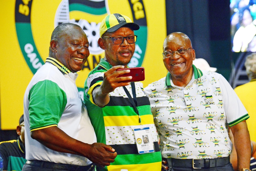 Een ANC-aanhanger maakt een foto van zichzelf tussen de nieuwe ANC-leider Cyril Ramaphosa (links) en zijn voorganger Jacob Zuma. (ap)